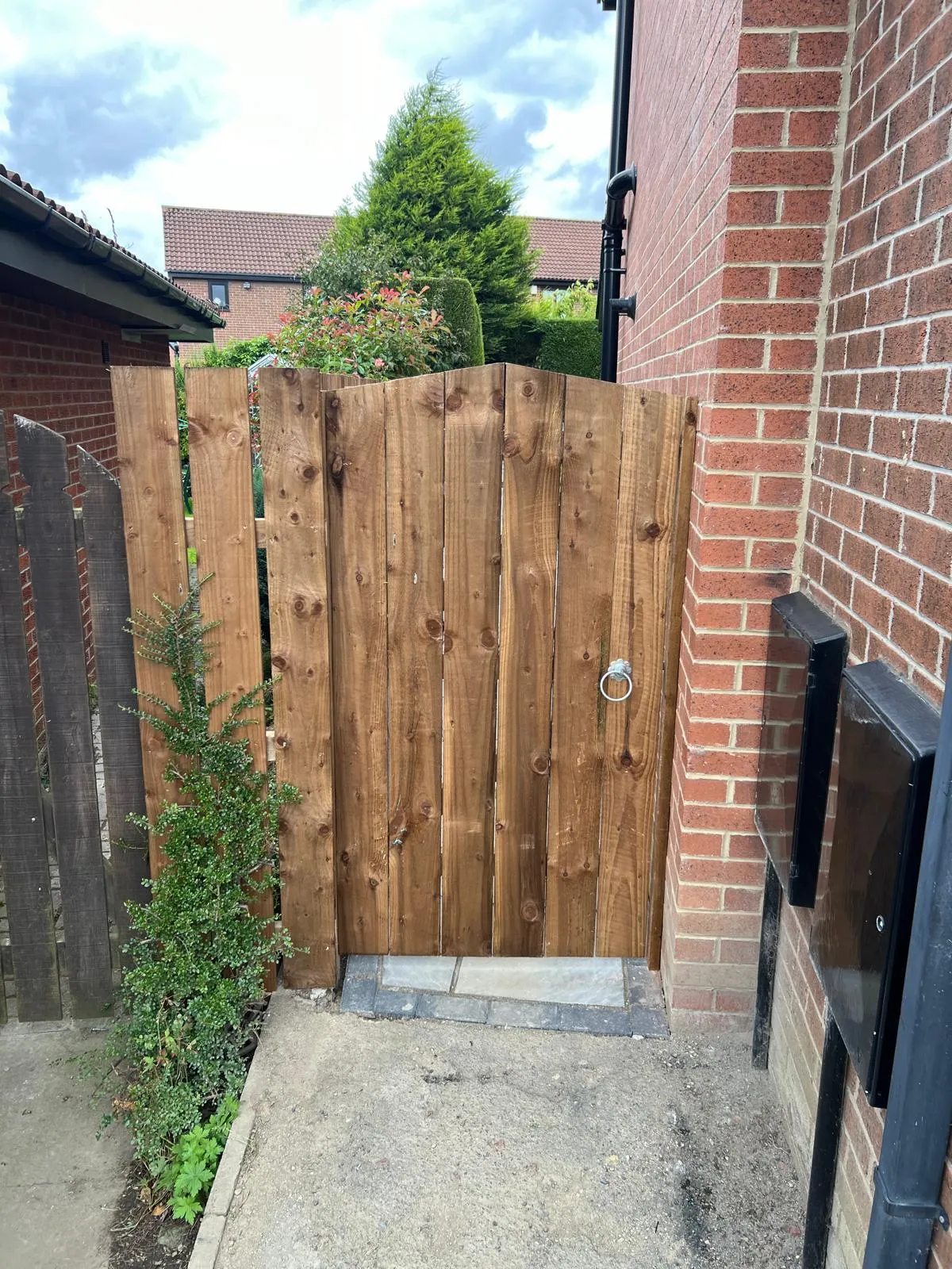 A wooden gate in front of a brick building.