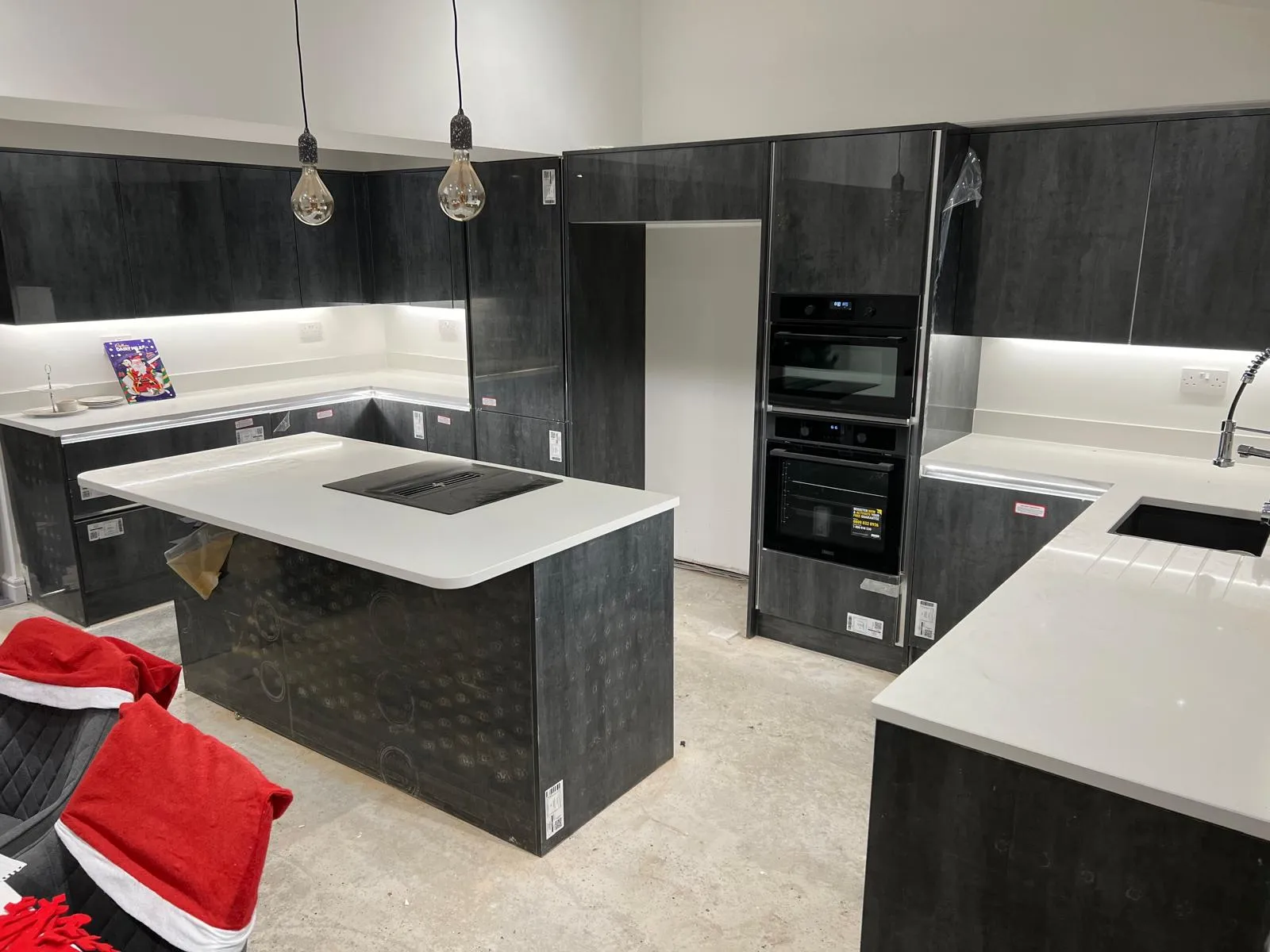 A kitchen with a stove, sink, oven and refrigerator.