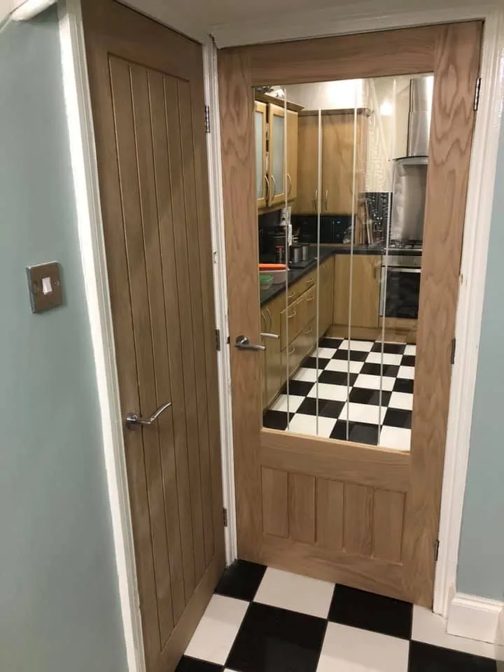 2 wooden doors with black and white flooring